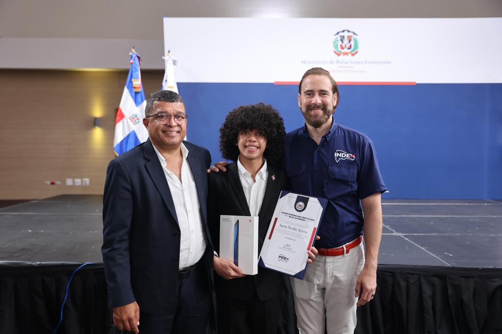 Aaron Azcona recibió el reconocimiento a estudiantes dominicanos destacados en el exterior, INDEX, de manos del Viceministro para las Comunidades Dominicanas en el Exterior, Carlos de la Mota.